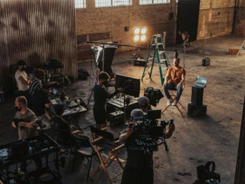 a group of people standing around a camera set up